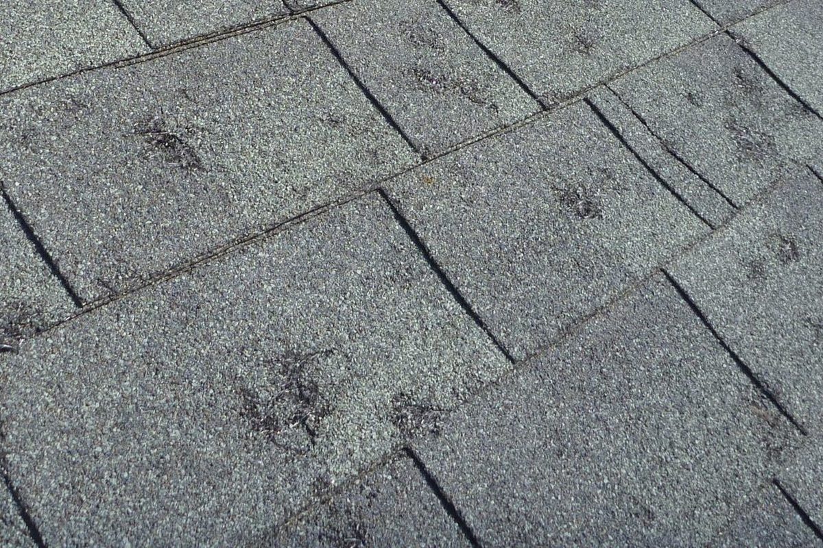 Emergency roof tarp installed on a storm damaged Kansas City home at night