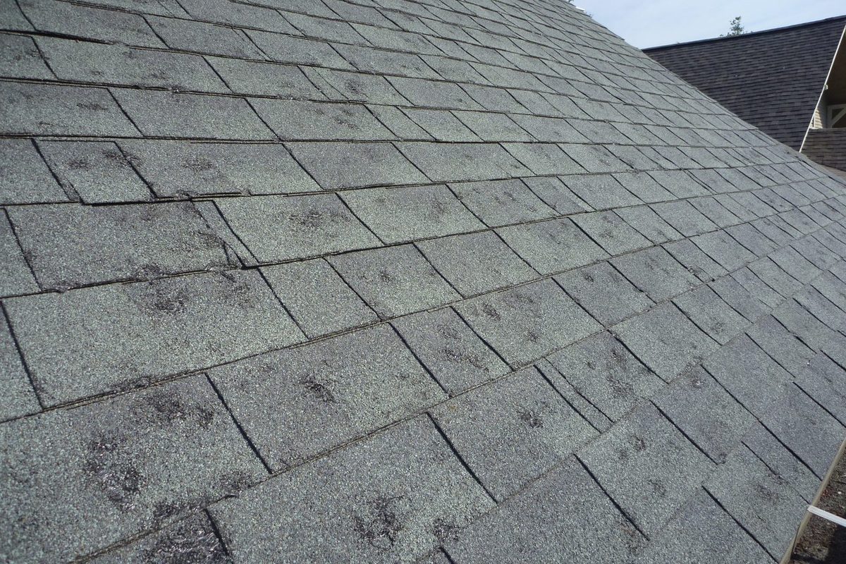 John Beal Roofing inspector photographing roof condition during a free Kansas City roof inspection