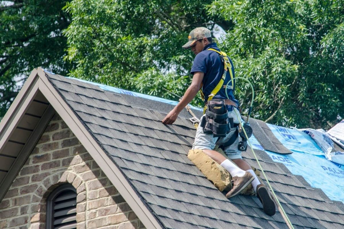 Kansas City roofer repairing damaged shingles and flashing on a residential roof
