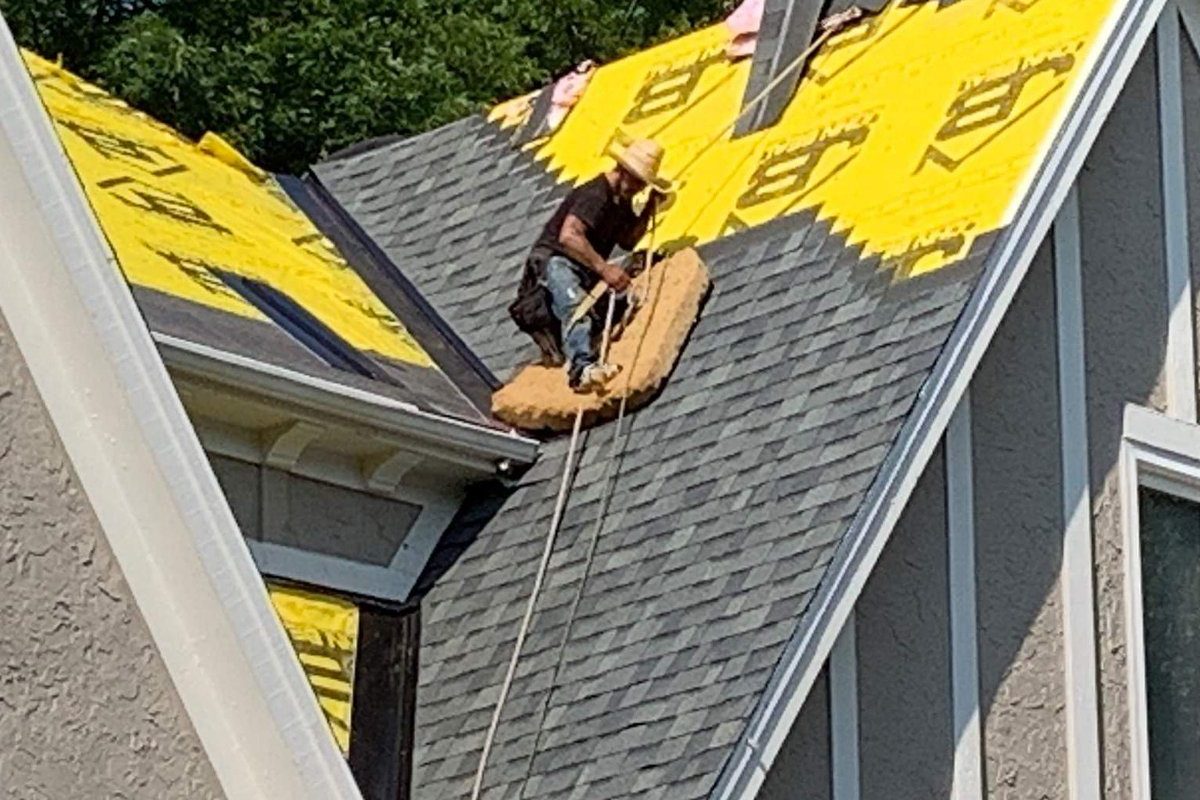 Kansas City roofing company crew installing new architectural shingles on a residential roof